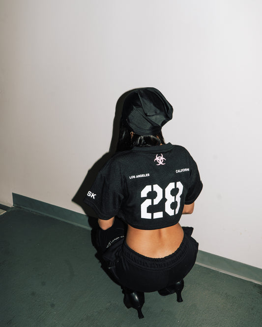 reward + risk cropped varsity jersey in black [women's]